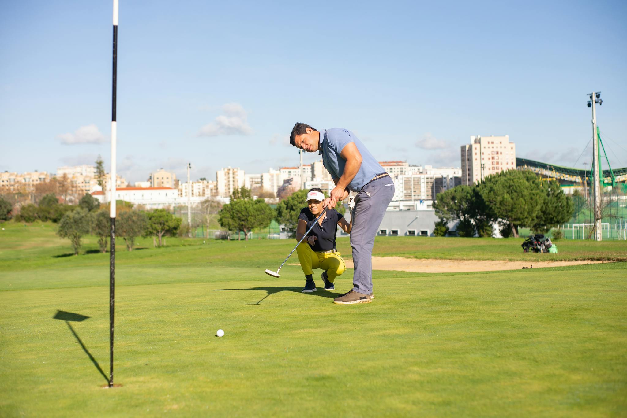 Golfers enjoying a sunny day while playing on an urban course in Portugal.